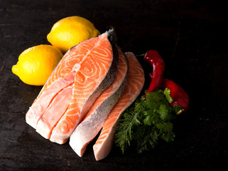 Raw salmon fish fillet on black background