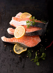 Raw salmon fish fillet on black background