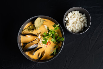 seafood soup and rice on the black background