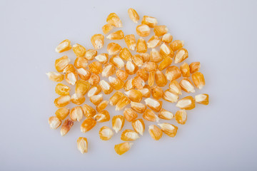 Yellow dry selective corn seeds isolated on white background. Gardening and agriculture. Selected seeds for planting in the agricultural field