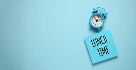 Foto op Plexiglas Blue alarm clock and paper reminder lunch time. © Andrii Zastrozhnov