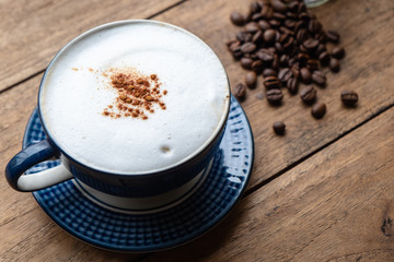 Capucino Coffee with Coffee Beans on the Old Wood Table