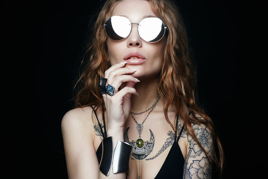 beauty tattooed girl in sunglasses and jewelry