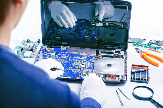 Computer Repair. Tech fixes motherboard in service center.