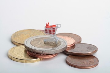 carrello della spesa in miniatura sopra delle monete