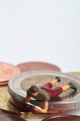 Obraz na płótnie Canvas miniature of people reading and euro coins