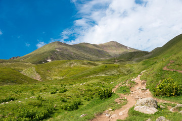 Kazbegi, Georgia - Jun 29 2018: Mountain range on a hiking trail from Gergeti Trinity Church to Gergeti Glacier. a famous landscape in Kazbegi, Mtskheta-Mtianeti, Georgia.