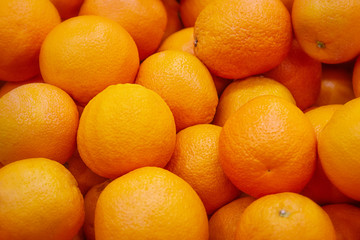 Obraz na płótnie Canvas Fresh mandarin oranges texture. Fresh oranges lying on the counter - orange and tangerine texture with round oranges and tangerines
