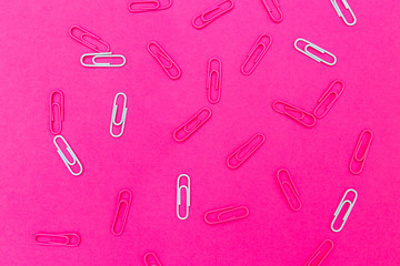 Paper clips on plastic pink background. Flat lay