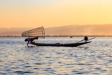 Naklejka premium Myanmar travel attraction landmark - Traditional Burmese fisherman at Inle lake, Myanmar famous for their distinctive one legged rowing style