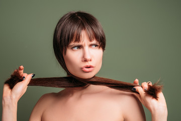Aggressive pretty woman. Hostile facial expression. Closeup portrait of emotional lady pulling...