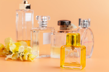 Perfume bottles with flowers petals on beige background
