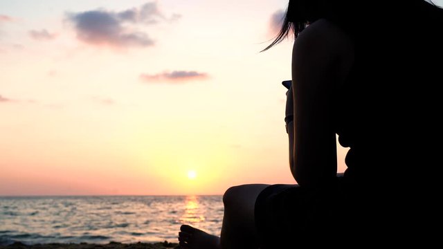 Phuket Sea Nai Thon Beach Woman sitting sunset, Thailand.