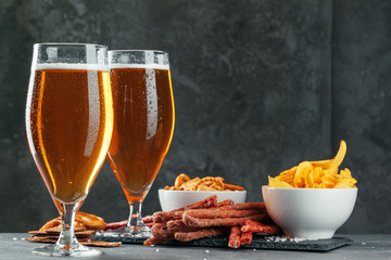  beer and appetizing beer snacks set. Table with mug of beer, wooden board with sausages