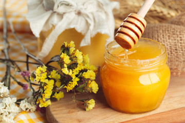 Honey background. Sweet honey in glass jar on wooden background.