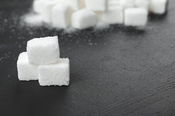 White sugar cubes over black background close up