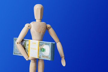Wooden toy figure with money on blue