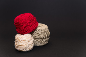 colored knitting yarn and hooks on a black background with space for text