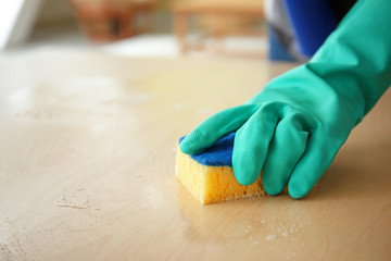 Woman cleaning table in room