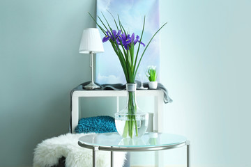 Vase with beautiful flowers on table in room