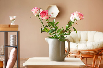 Vase with beautiful flowers on table in room