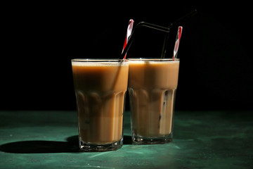 Glasses of tasty frappe coffee on dark background