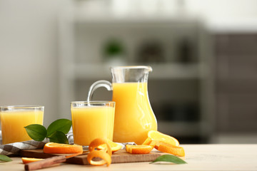 Tasty orange juice on table in kitchen