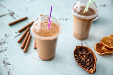 Cups of tasty frappe coffee on light table