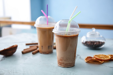 Cups of tasty frappe coffee on light table