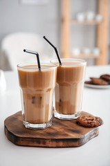 Glasses of tasty frappe coffee on white table