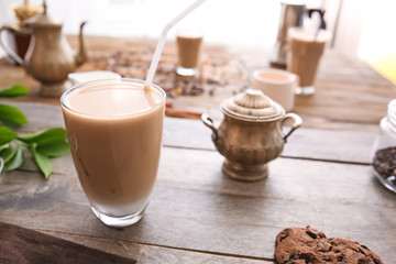 Glass of tasty frappe coffee on wooden table