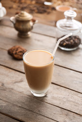 Glass of tasty frappe coffee on wooden table