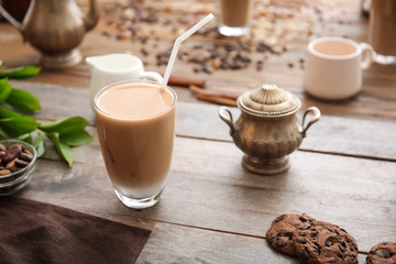 Glass of tasty frappe coffee on wooden table