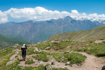Fototapeta na wymiar Kazbegi, Georgia - Jun 29 2018: Hiker on Mountain range on a hiking trail from Gergeti Trinity Church to Gergeti Glacier. a famous landscape in Kazbegi, Mtskheta-Mtianeti, Georgia.