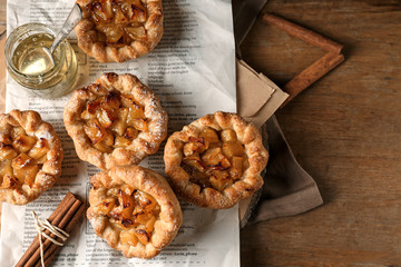 Tasty apple pies on wooden table