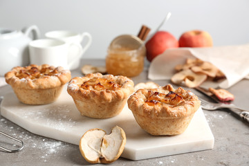 Tasty apple pies on grey table