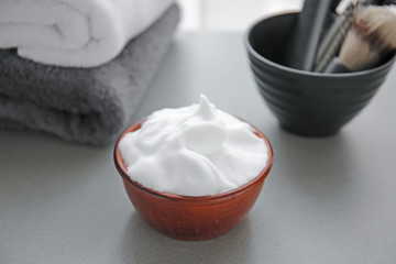 Bowl with shaving foam on grey table