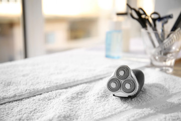 Towel with electric shaver on table