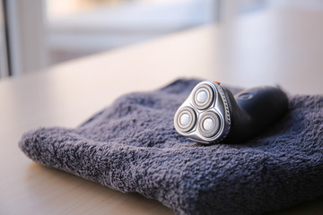 Towel with electric shaver on table