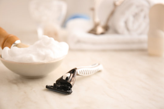 Razor And Bowl With Shaving Foam On Table