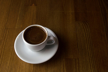 a cup of coffee with milk and brown table