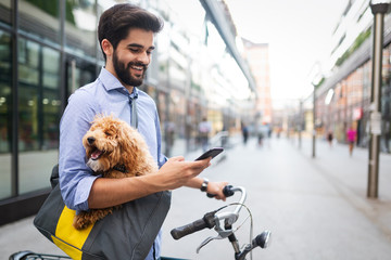 Happy handsome man with bicycle using mobile outdoor