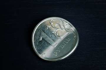 Sanctions and inflation concept. Bent Russian ruble on dark wooden background.