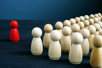 Leadership in business and company. Red figurine in front of crowd.
