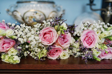 Large centerpiece with pink and white roses and fresh foliage suitable as a decor for table centerpieces at a wedding reception ceremony or as an elegant interior decoration