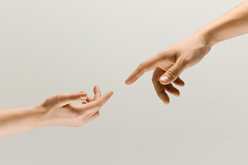 Moment of weightless. Two male hands trying to touch like a creation of Adam sign isolated on grey studio background. Concept of human relation, community, togetherness, symbolism, culture and history - obrazy, fototapety, plakaty