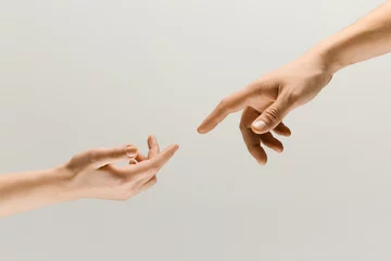 Fotobehang Moment of weightless. Two male hands trying to touch like a creation of Adam sign isolated on grey studio background. Concept of human relation, community, togetherness, symbolism, culture and history © master1305