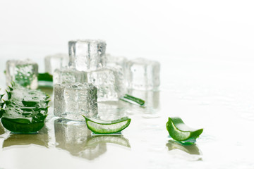 Aloe leaf and ice cubes on a light background. Refreshing and cooling for skin, anti-thirst drink.