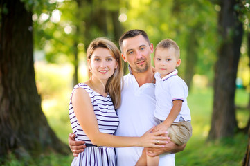 Fototapeta premium Loving family. Happy young family spending time together having fun in summer park, people concept. Family еnjoying time together