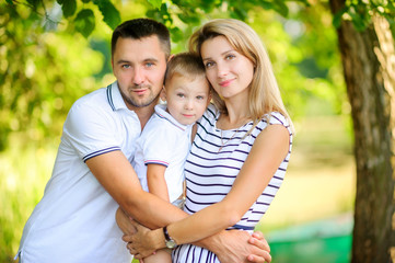 Fototapeta premium Loving family. Happy young family spending time together having fun in summer park, people concept. Family еnjoying time together